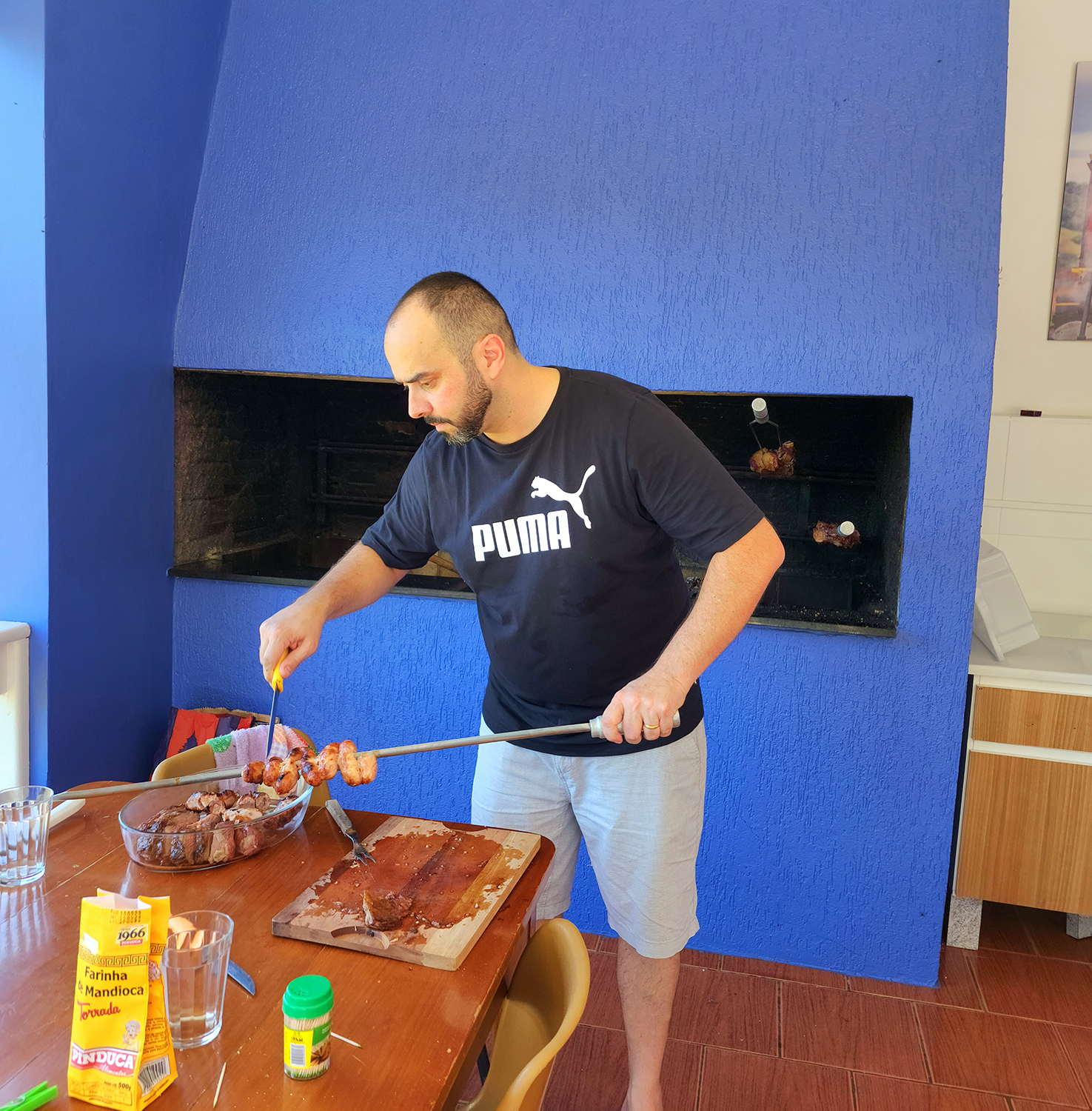 Hóspede preparando churrasco na área de convivência da Pousada do Lago